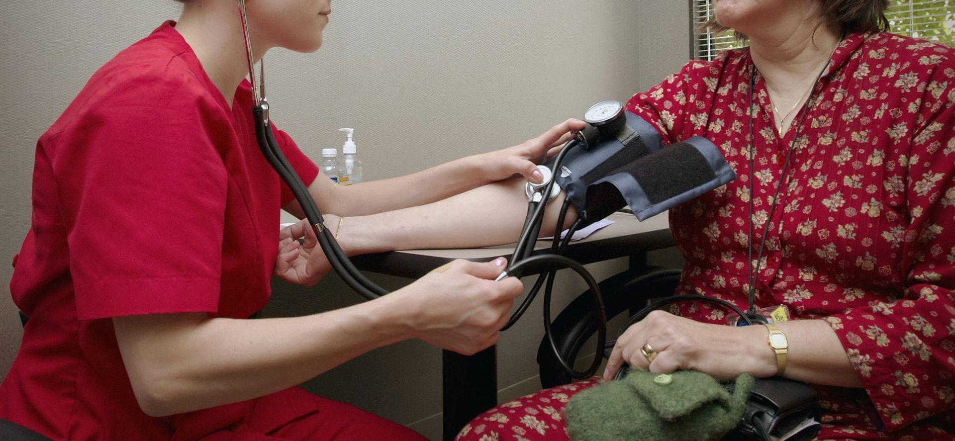 a woman with a stethoscope listening to a patient